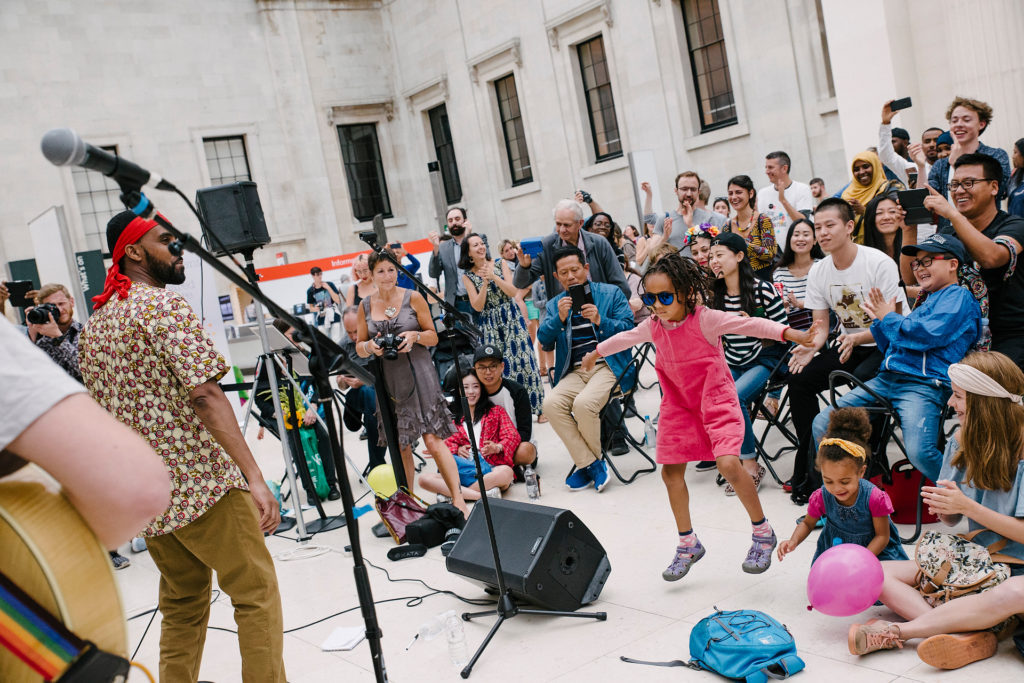 Girl in shades jumps to music at Refugee Week 2017 at British Museum